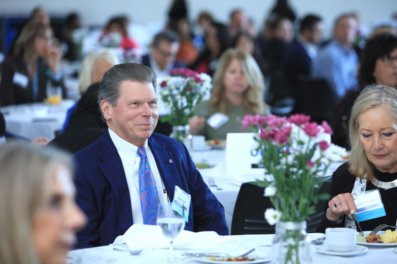 Breakfast guest seated, smiling.
