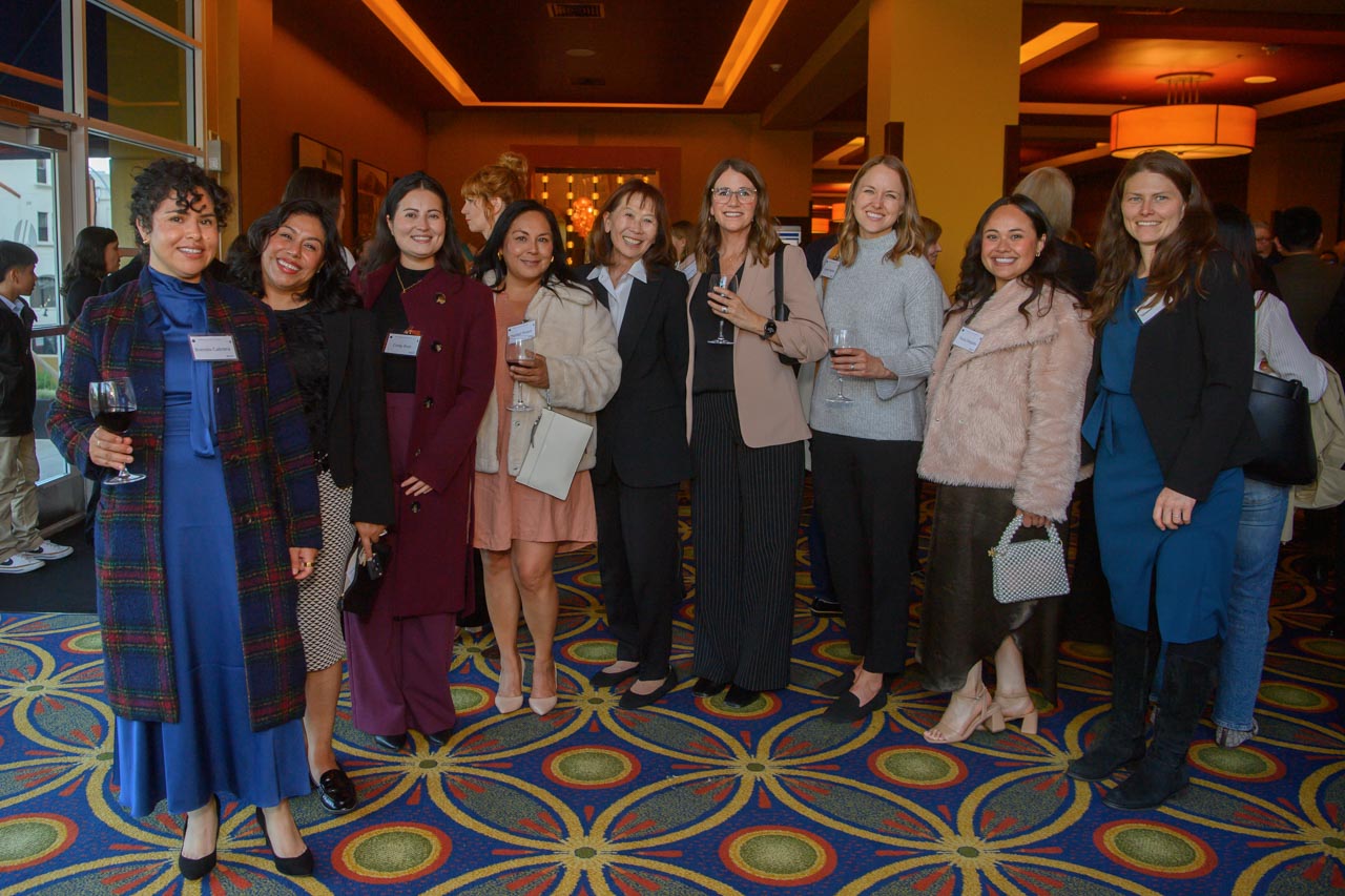 Group of women,  some holding wine glasses