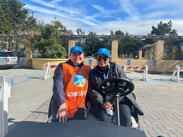 Two volunteers sitting in a golf cart