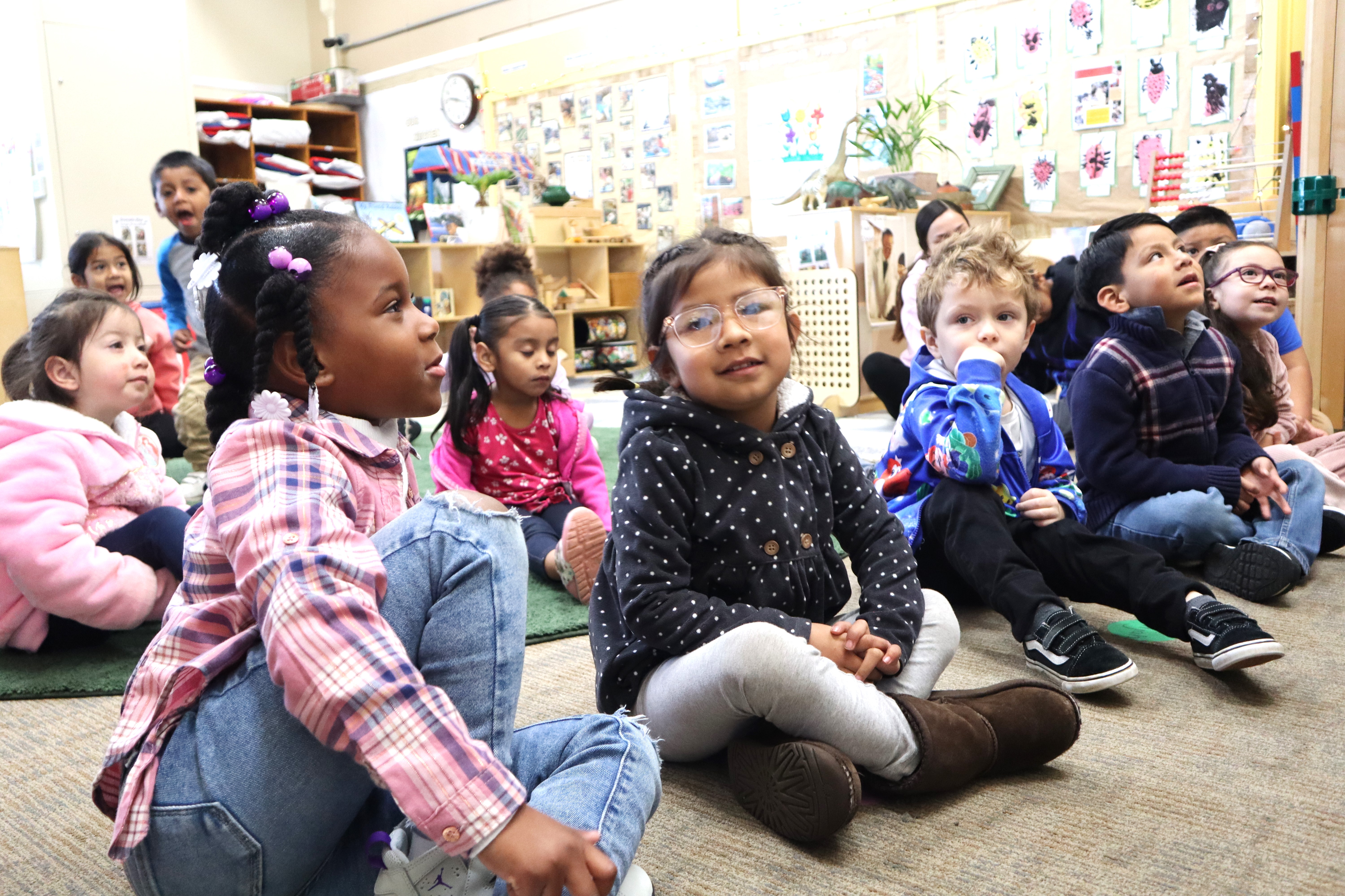 Children sitting on the ground in a classroom