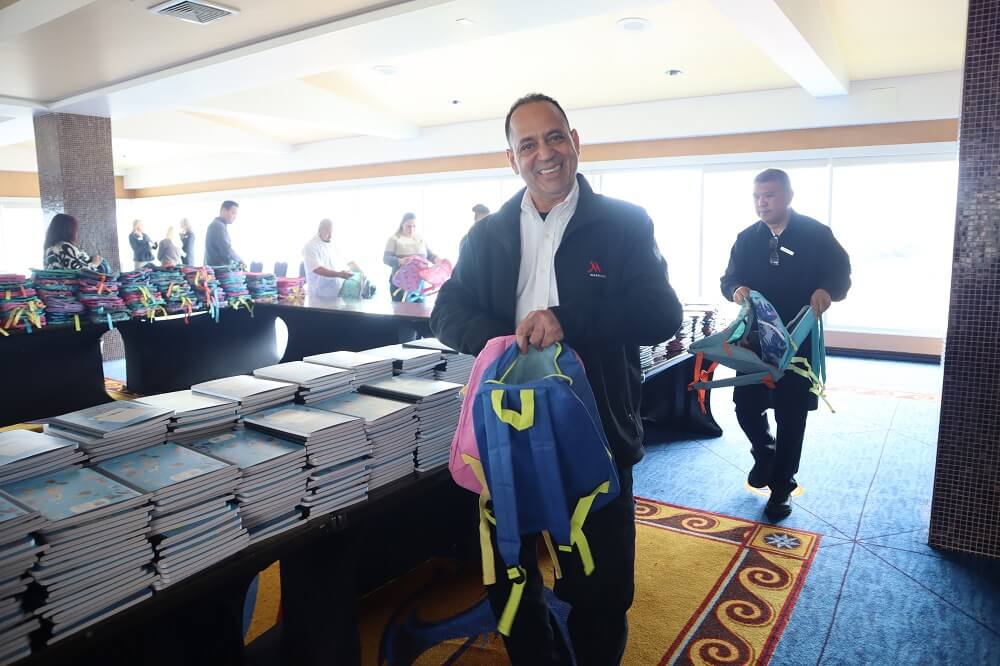 Volunteer holding two backpacks