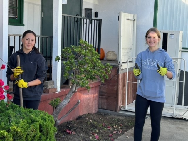Two volunteers cleaning up the garden