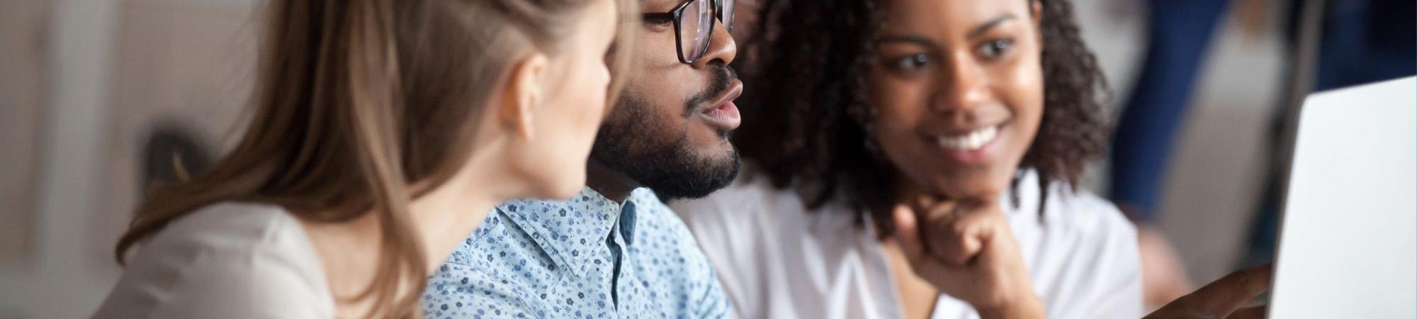 Three people working on a computer