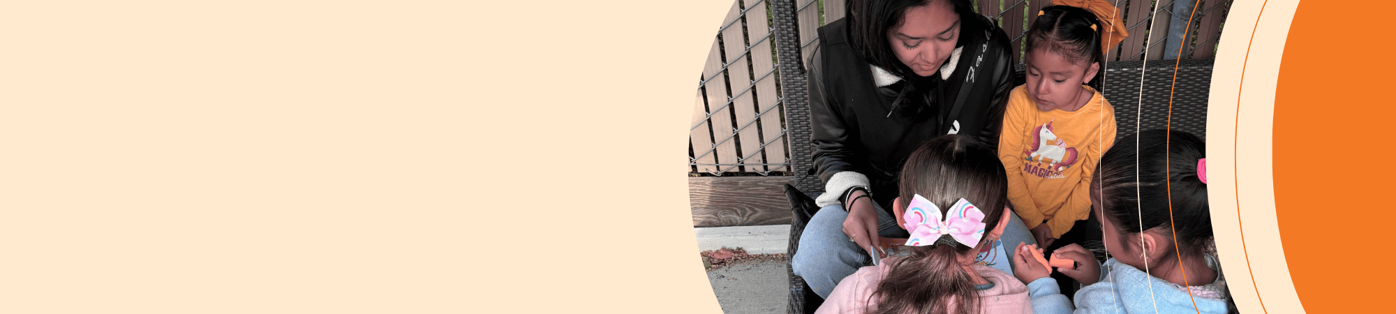 Young Woman sitting with three preschool children reading a book
